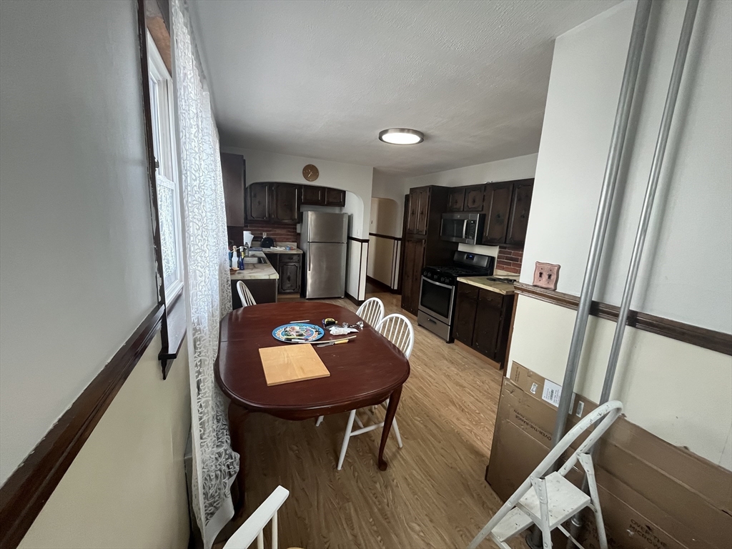 32 Howell Street, Unit 2 Boston, MA 02125 - Photo 5 of 24 a kitchen with stainless steel appliances wooden floor dining table and chairs