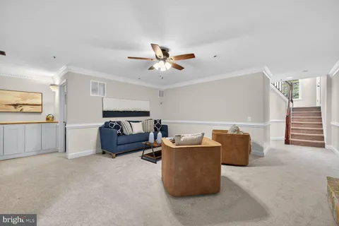 a living room with furniture and a ceiling fan