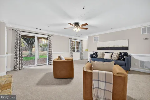 a living room with furniture and a ceiling fan