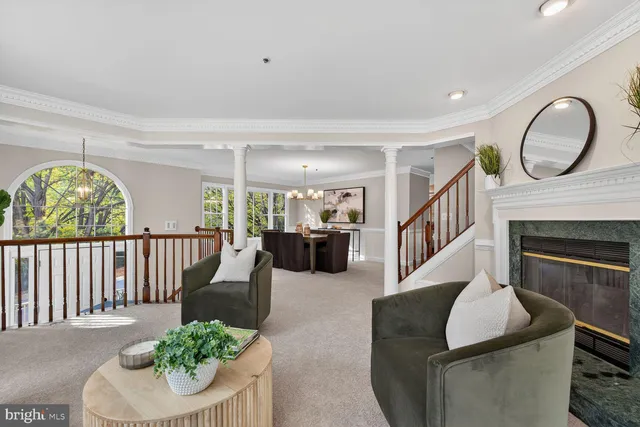a living room with furniture a fireplace and a floor to ceiling window