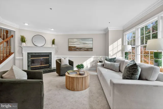 a living room with furniture a fireplace and a large window