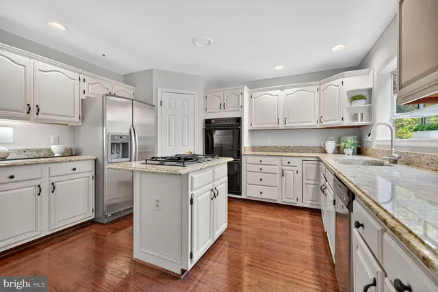 a kitchen with granite countertop white cabinets and white appliances