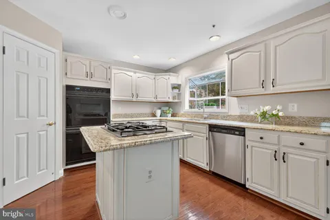 a kitchen with granite countertop cabinets stainless steel appliances and wooden floor