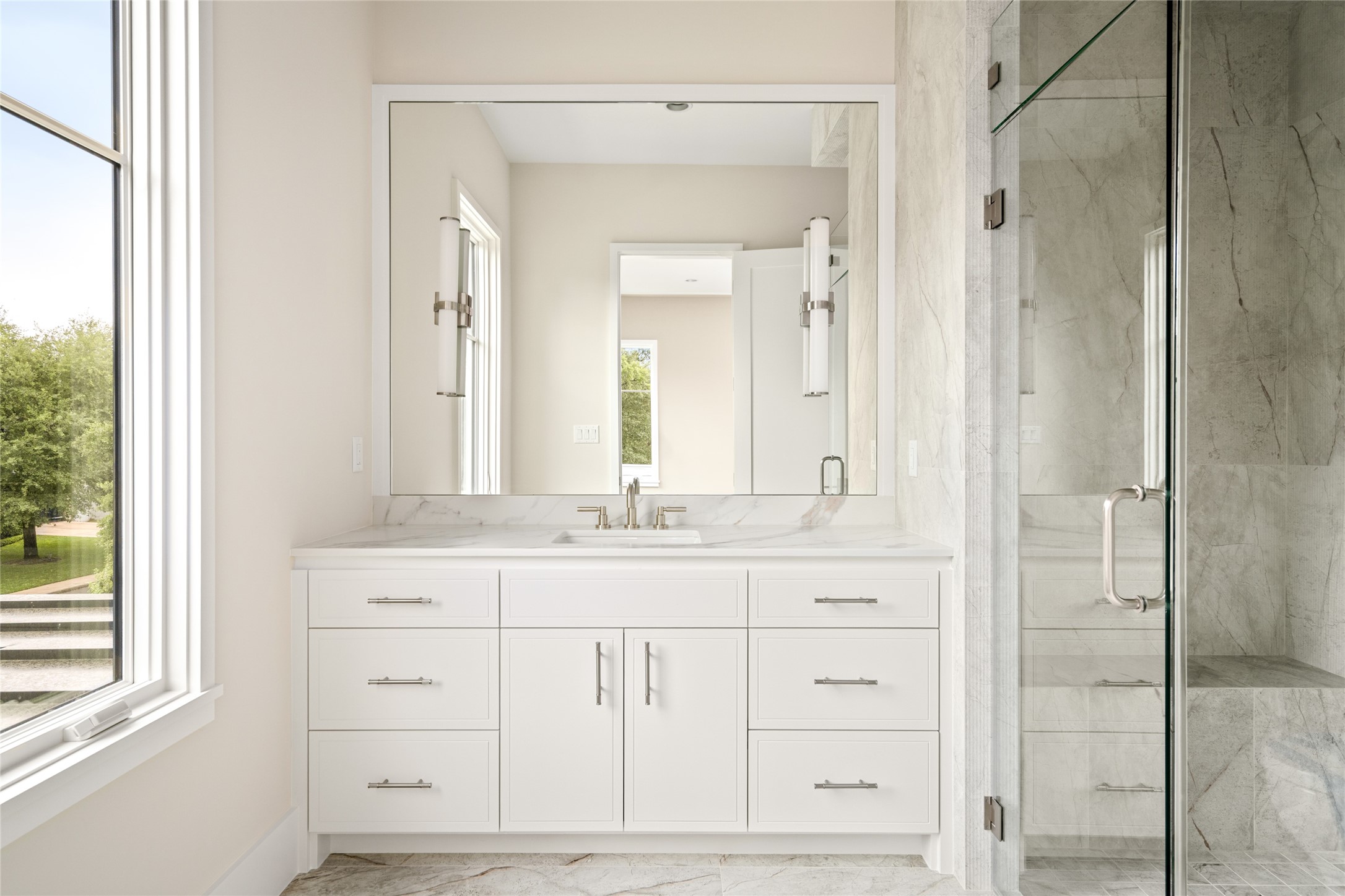 4006 Overbrook Lane Houston, TX 77027 - Photo 25 of 50 A thoughtfully designed secondary bath where quartzite and fluted textures add depth to the walk-in shower with built-in bench.