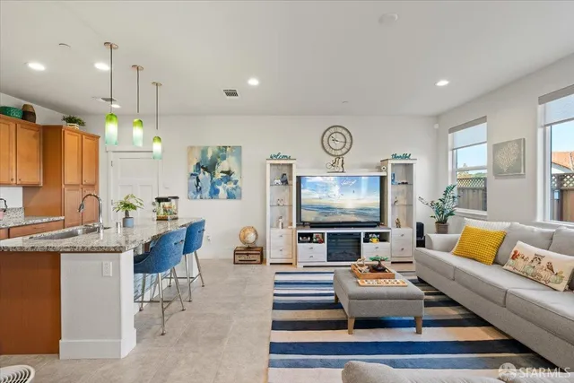 a kitchen with kitchen island stainless steel appliances a stove a sink a oven a dining table and chairs