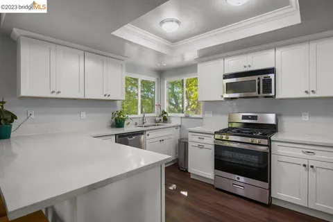 a kitchen with stainless steel appliances a sink dishwasher stove microwave and cabinets