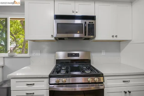 a view of a dining room with furniture a chandelier and large windows