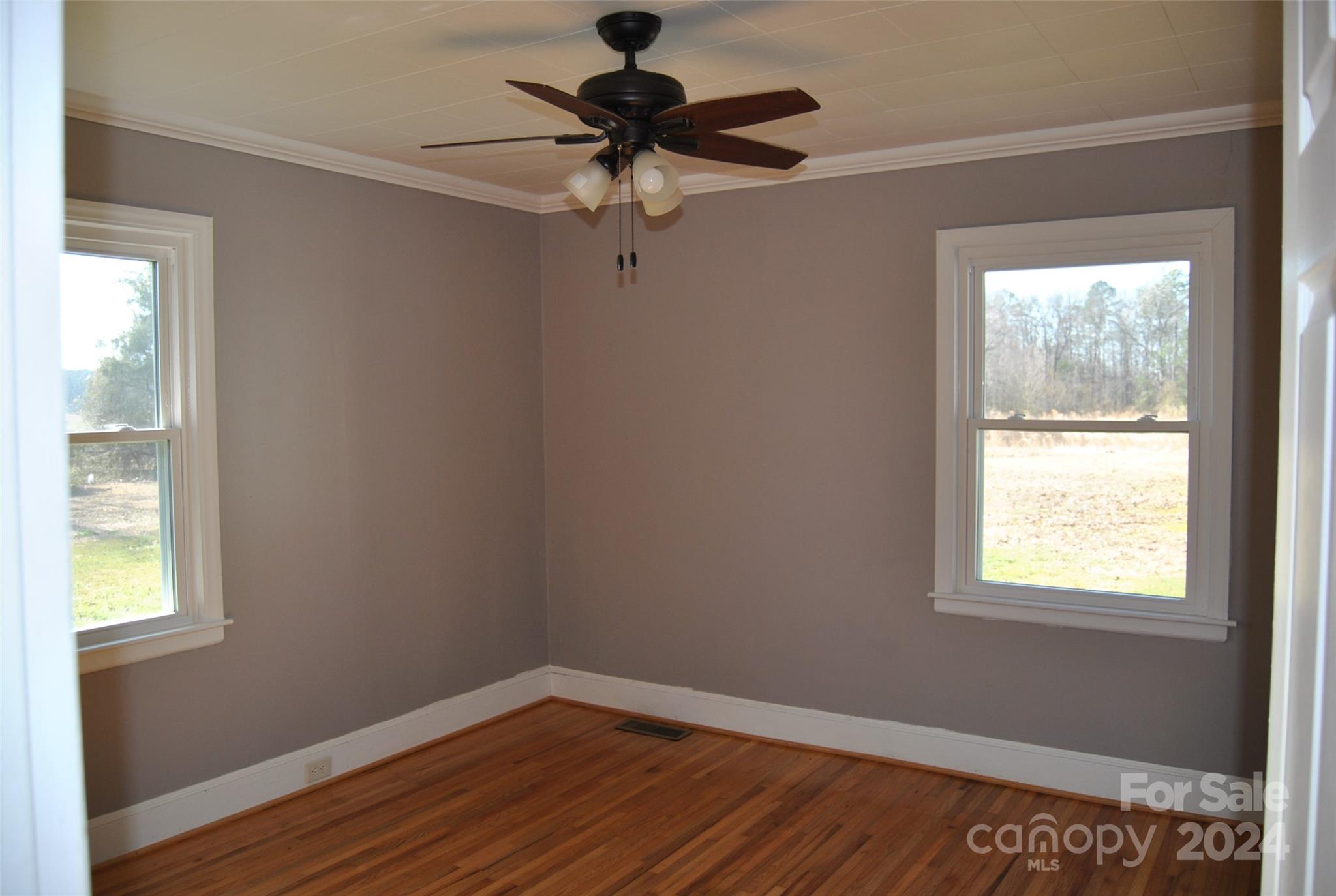 2122 Old Pageland Monroe Road Monroe, NC 28112 - Photo 3 of 24 a view of an empty room with wooden floor and a window