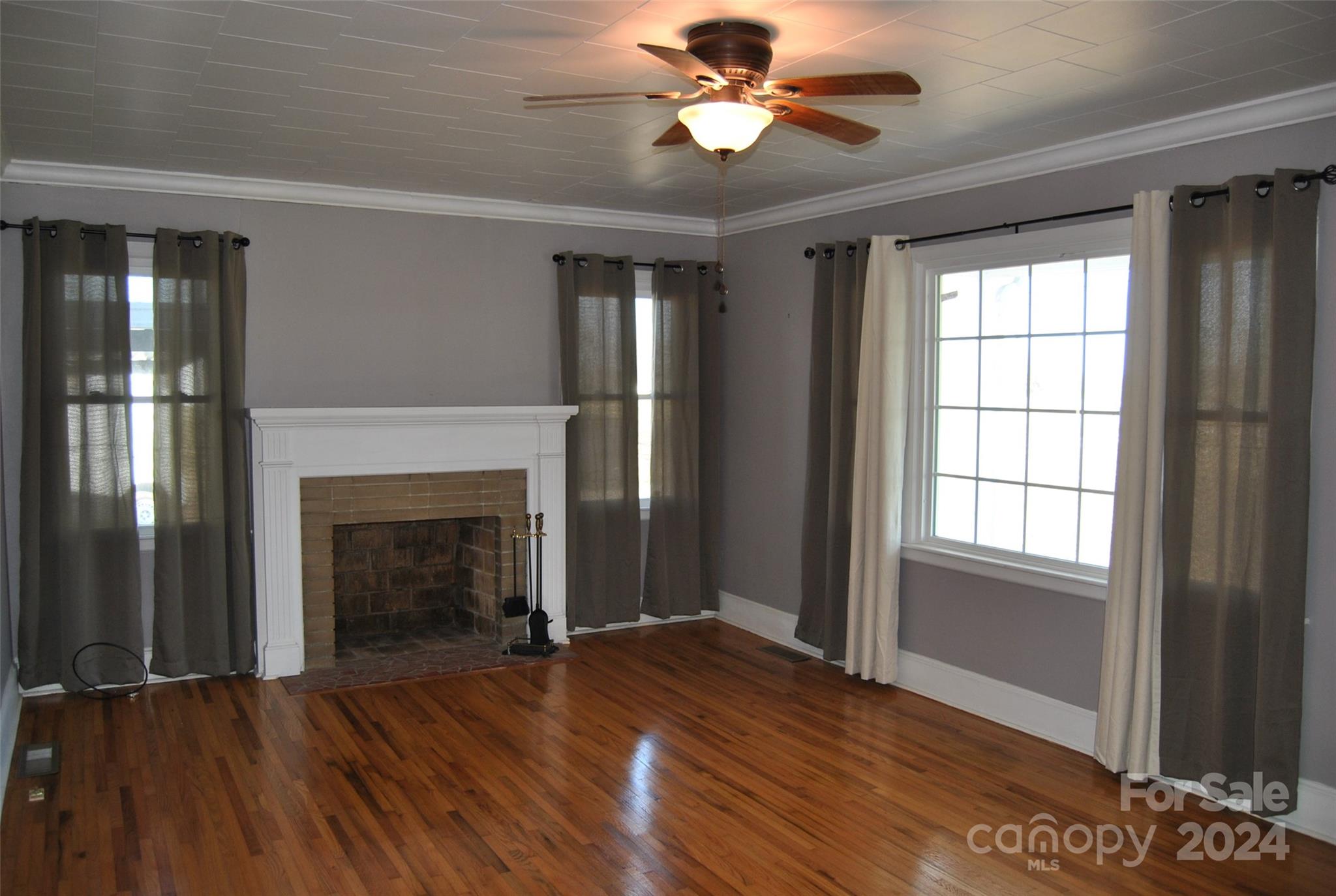 2122 Old Pageland Monroe Road Monroe, NC 28112 - Photo 9 of 24 a view of an empty room with wooden floor fireplace and a window