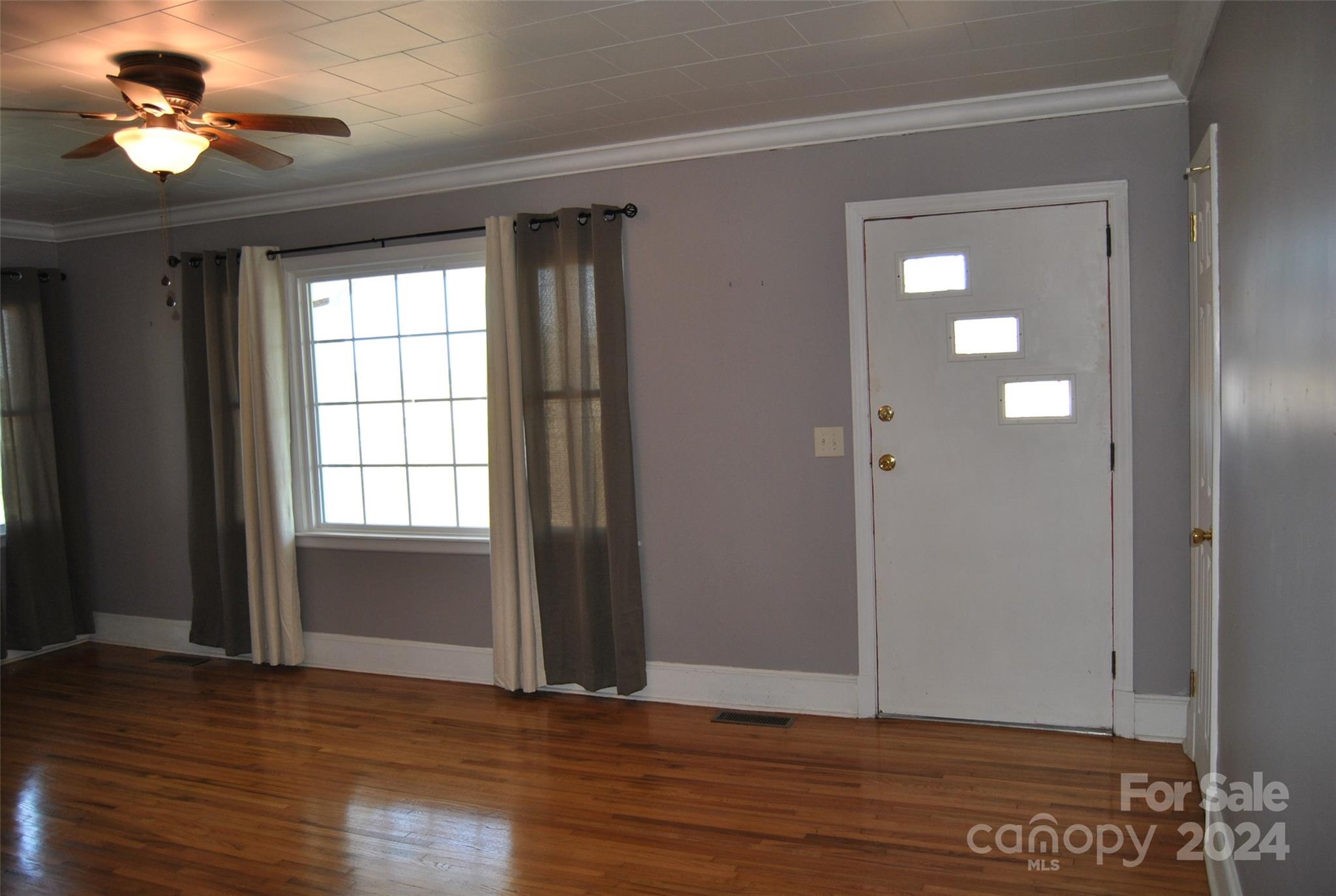 2122 Old Pageland Monroe Road Monroe, NC 28112 - Photo 10 of 24 a view of an empty room with window a ceiling fan and wooden floor