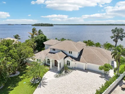 an aerial view of a house with yard and lake view