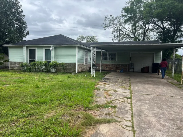 a front view of a house with a yard and trees