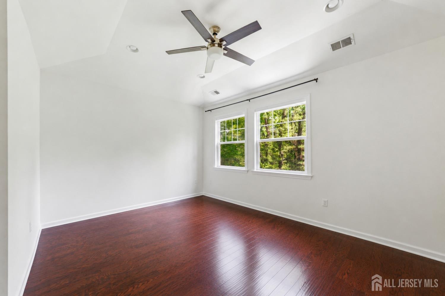 133 Savoth Lane Colonia, NJ 07067 - Photo 12 of 21 an empty room with wooden floor ceiling fan and windows