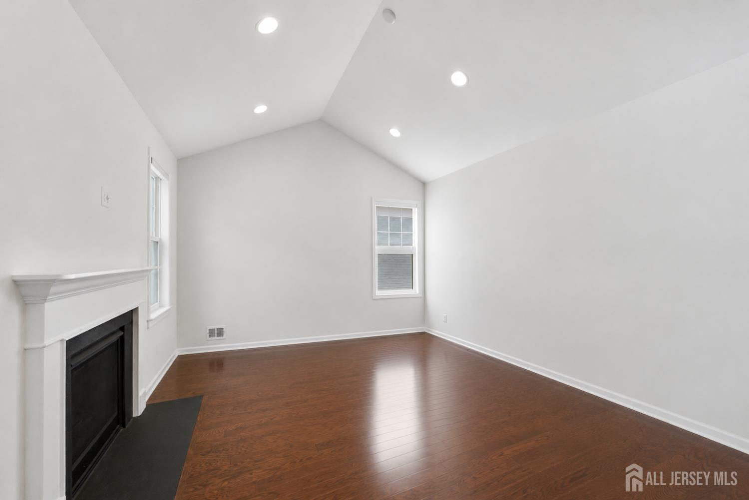 133 Savoth Lane Colonia, NJ 07067 - Photo 5 of 21 a view of empty room with wooden floor and fireplace