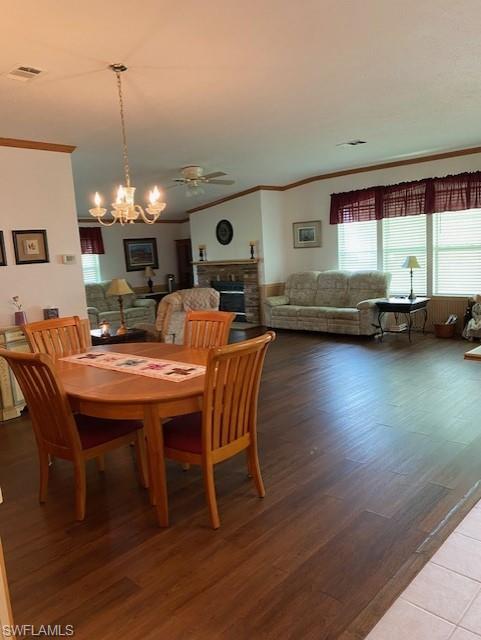 298 Riverwood Road Naples, FL 34114 - Photo 14 of 39 a dining room with wooden floor a chandelier a glass table and chairs