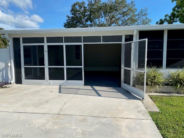 298 Riverwood Road Naples, FL 34114 - Photo 4 of 39 front view of a house with a large window and a yard