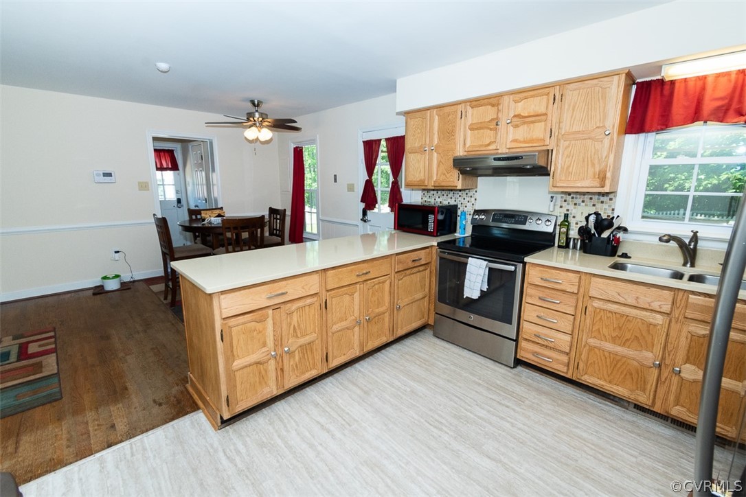 7110 Barkbridge Road Chesterfield, VA 23832 - Photo 8 of 34 a kitchen with stainless steel appliances a stove a sink and white cabinets with wooden floor