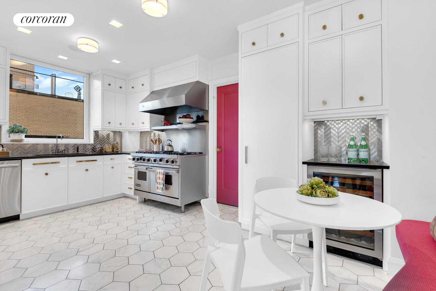 1220 Park Avenue, Unit 13D Manhattan, NY 10128 - Photo 7 of 19 a kitchen with stainless steel appliances white cabinets sink and a stove