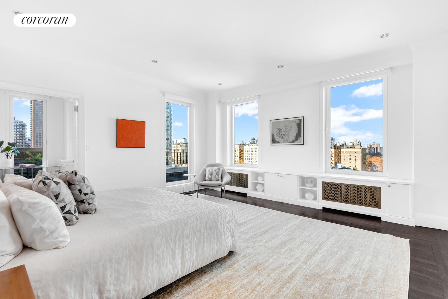 1220 Park Avenue, Unit 13D Manhattan, NY 10128 - Photo 9 of 19 a spacious bedroom with a bed a table and painting on the wall