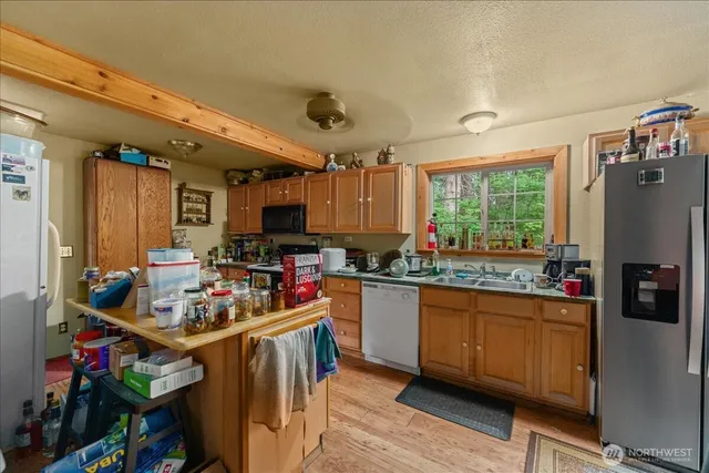 a kitchen with kitchen island granite countertop lots of counter top space and stainless steel appliances