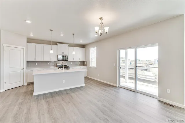 a view of a kitchen with wooden floor and a window