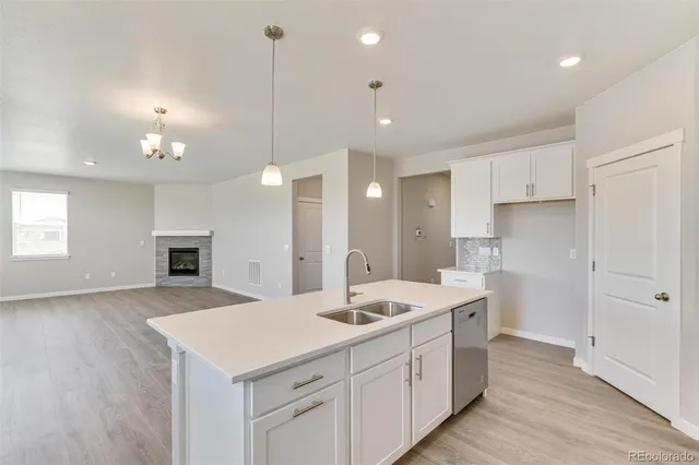 a view of a kitchen counter space with sink refrigerator and window