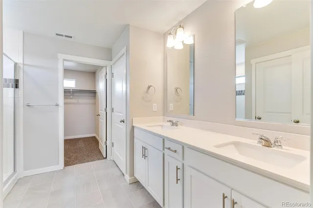 a bathroom with a double vanity sink and a mirror