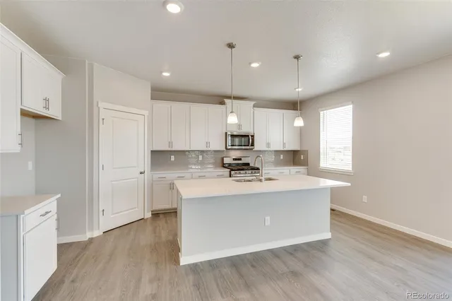 a kitchen with kitchen island a sink and a stove top oven