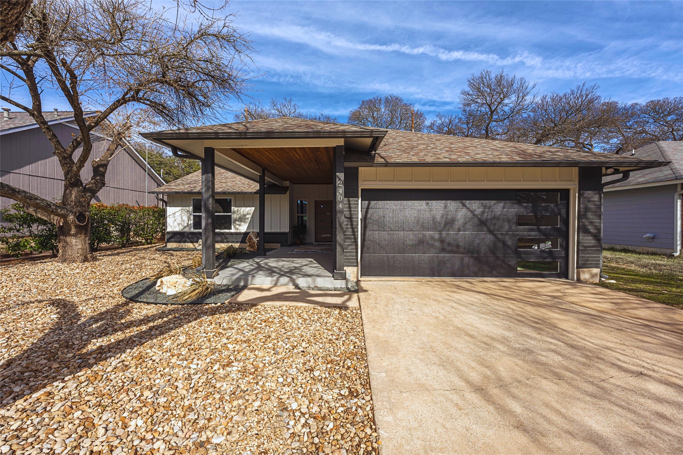 2404 Monarch Drive Austin, TX 78748 - Photo 1 of 25 View of front of home with a garage, driveway, board and batten siding, roof with shingles, and a porch