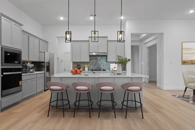 a kitchen with kitchen island granite countertop a sink and white appliances
