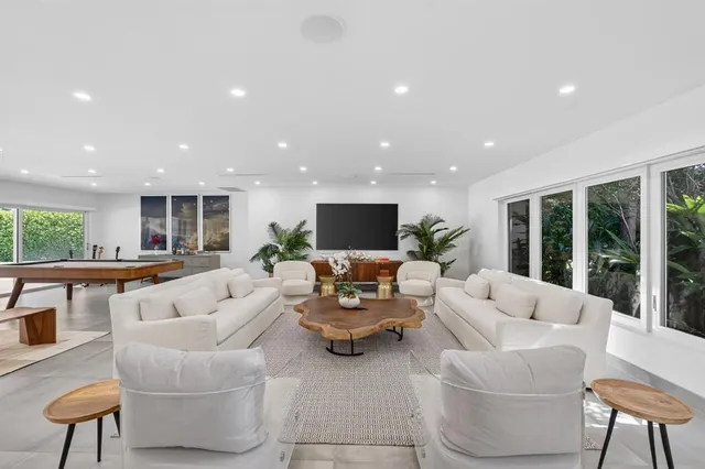 a view of a patio with couches table and chairs and potted plants
