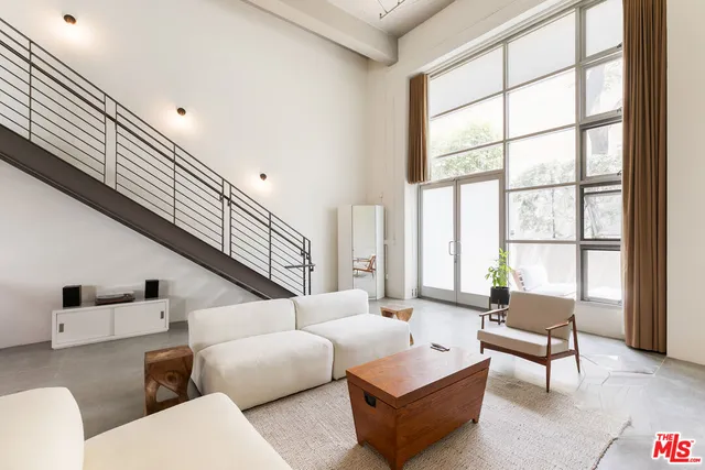 a living room with furniture and floor to ceiling windows