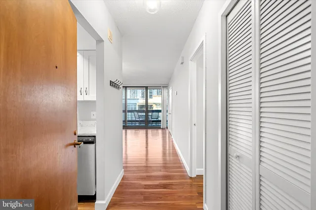 a view of a hallway with wooden floor and staircase