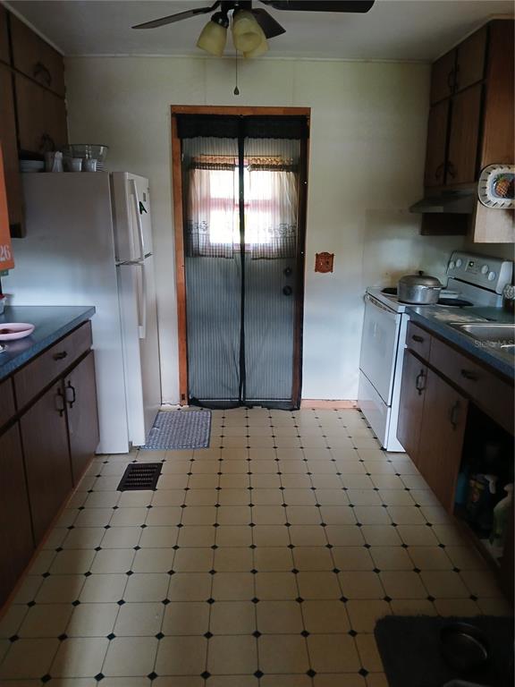 171 Melhorn Road Haines City, FL 33844 - Photo 5 of 13 a kitchen with a sink a refrigerator and cabinets