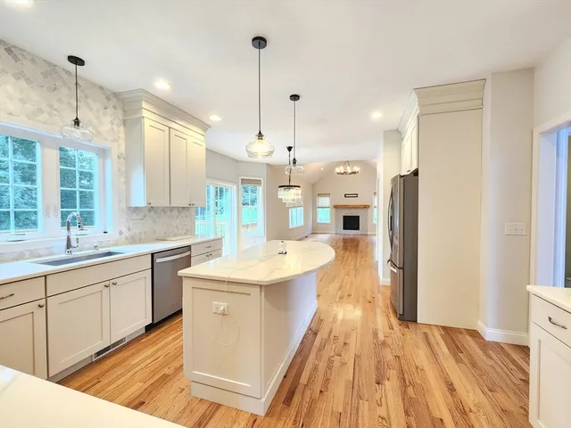 a large kitchen with kitchen island a sink appliances and a counter space