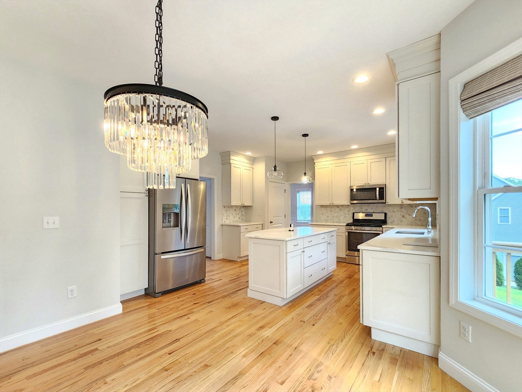16 Exeter Road Hudson, MA 01749 - Photo 14 of 42 a view of a kitchen with kitchen island a refrigerator wooden floor and a view of living room