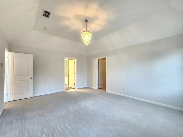 an empty room with windows and ceiling fan