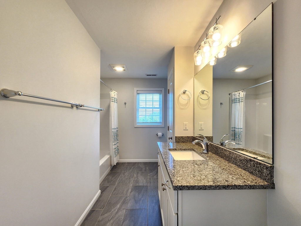 16 Exeter Road Hudson, MA 01749 - Photo 28 of 42 a bathroom with a granite countertop sink a mirror and a shower