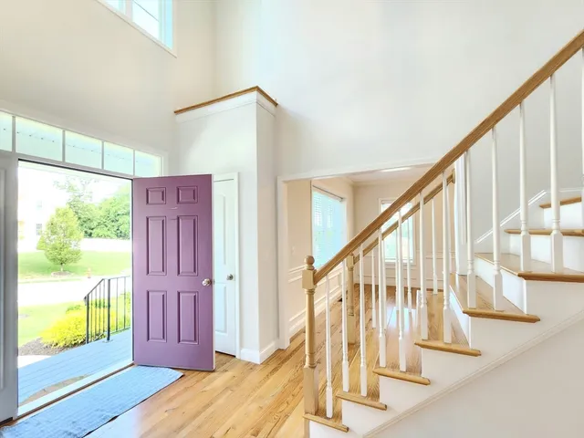 a view of an entryway with wooden floor door and windows