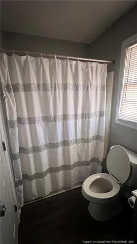 a bathroom with a toilet and a shower curtain