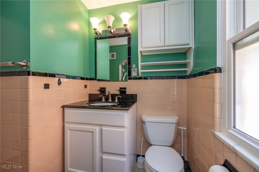 21475 Eaton Road Cleveland, OH 44126 - Photo 25 of 31 Bathroom with vanity, toilet, tile walls, and decorative backsplash