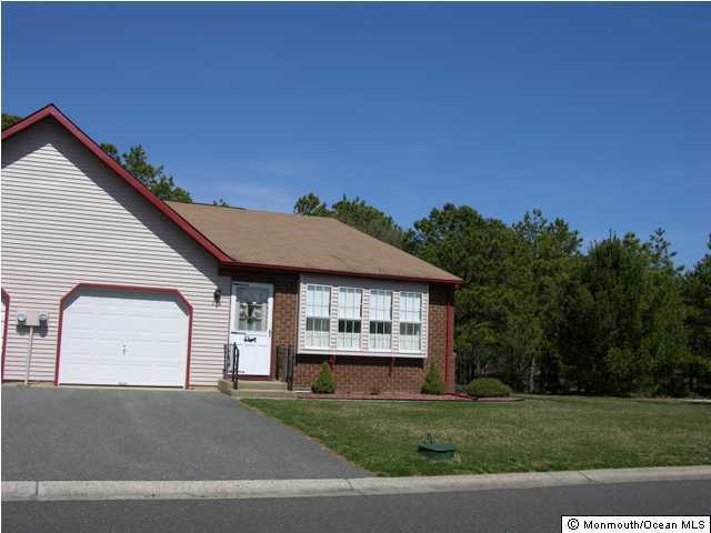 35A Sunset Road, Unit B Whiting, NJ 08759 - Photo 1 of 3 a front view of a house with a garden and trees