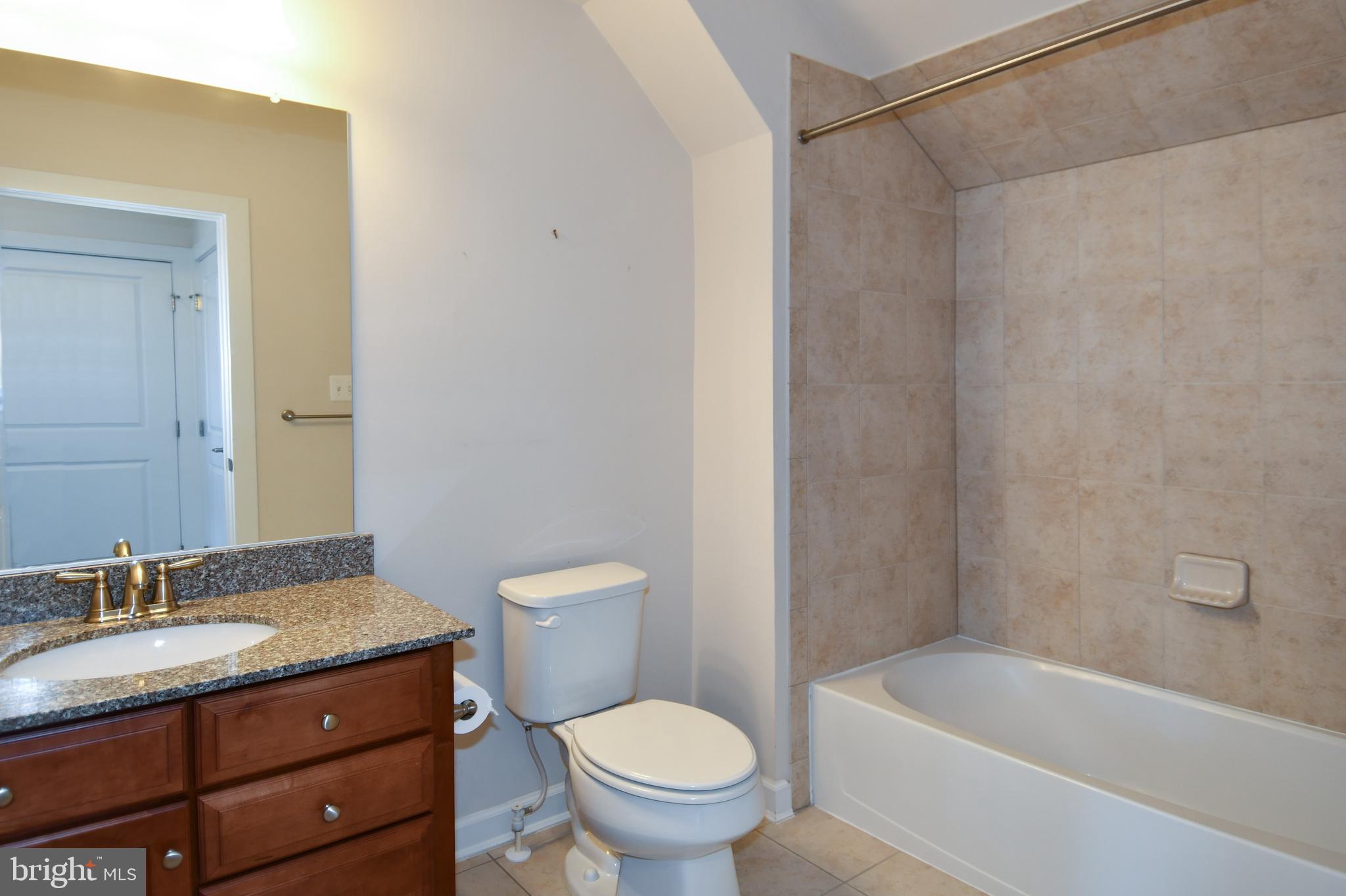 409 Hydrangea Place Gaithersburg, MD 20878 - Photo 40 of 49 a bathroom with a granite countertop toilet a sink and a bathtub