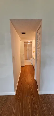 a view of a room with wooden floor and a hallway