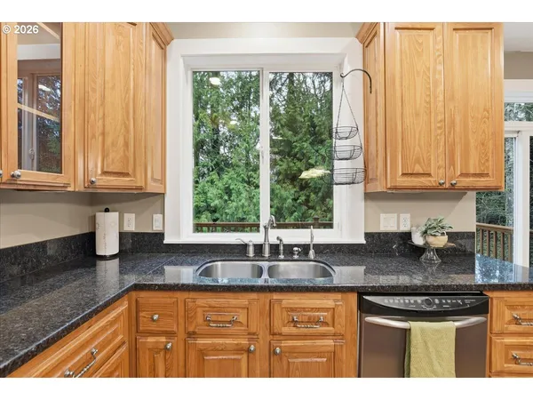 a kitchen with stainless steel appliances granite countertop a sink a stove and next to a window