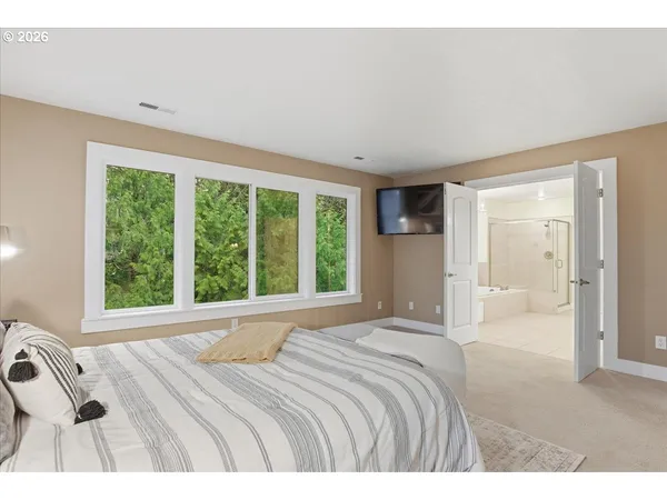 a bedroom with a bed and a large window