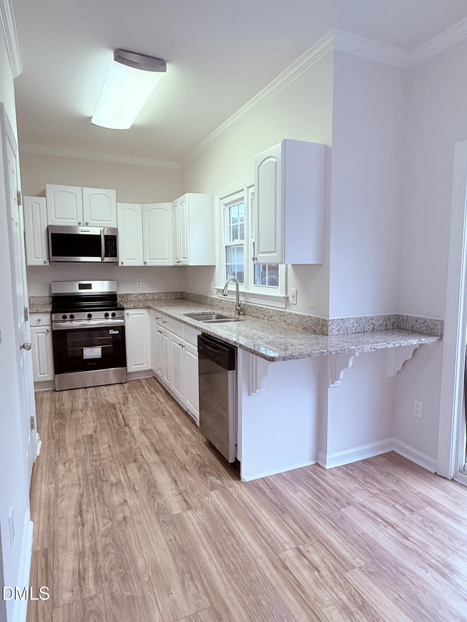 4204 Belington Court Raleigh, NC 27604 - Photo 4 of 18 a kitchen with stainless steel appliances granite countertop a stove a sink and a microwave
