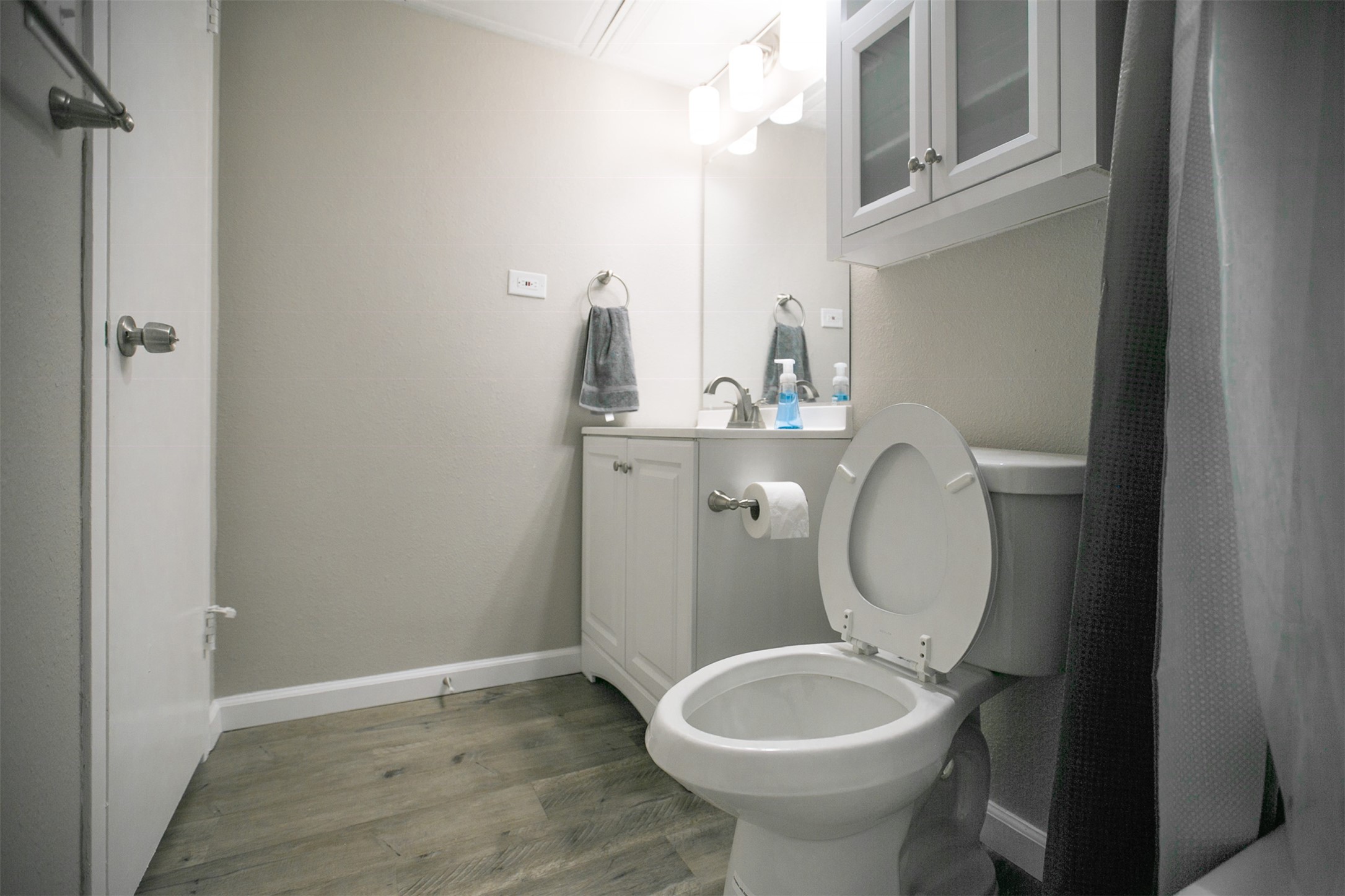 1800 Lavaca Street, Unit A608 Austin, TX 78701 - Photo 11 of 12 Full bathroom with vanity, light wood-style flooring, and curtained shower