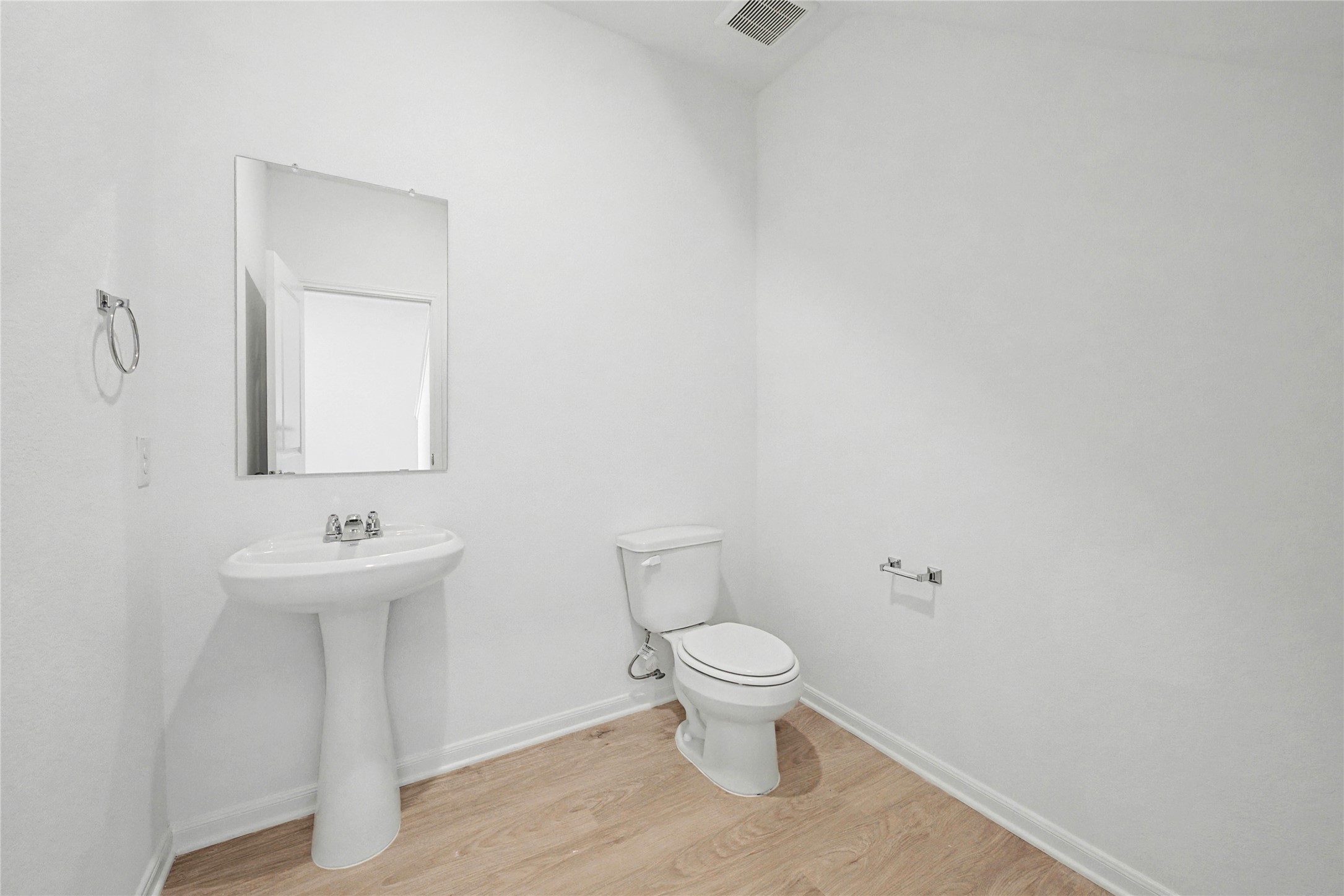237 Fairlawn Way Maxwell, TX 78656 - Photo 5 of 12 Bathroom featuring a pedestal sink with a chrome faucet, a wall-mounted mirror, and wood-look flooring