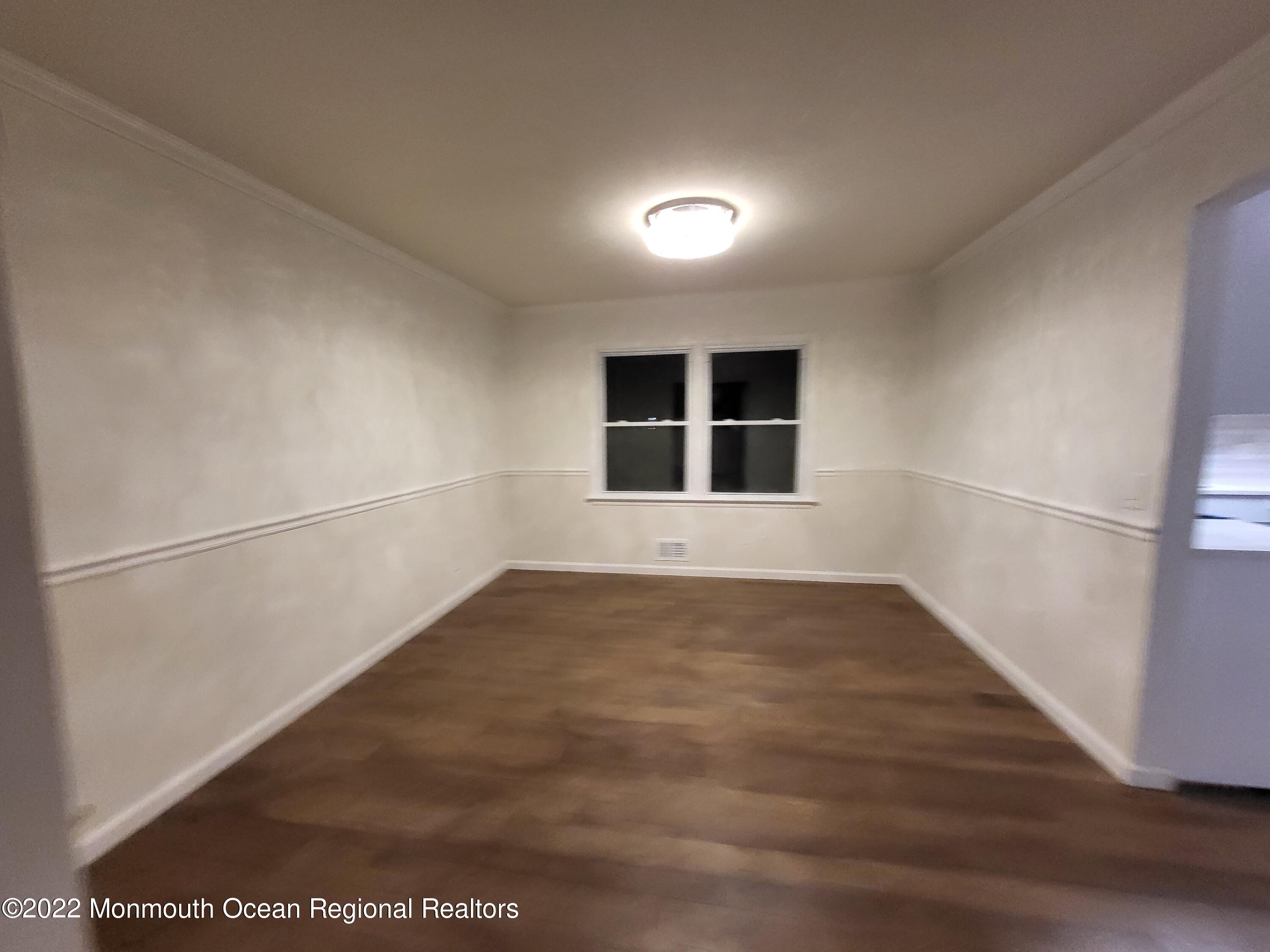 13 Spicy Pond Road Howell, NJ 07731 - Photo 5 of 7 an empty room with wooden floor and windows